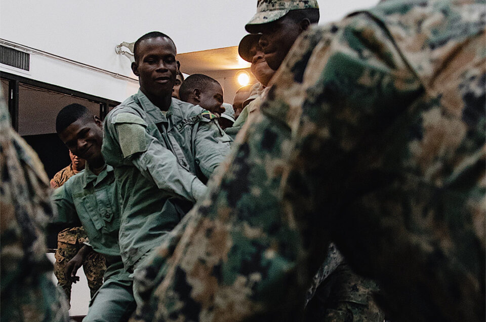 JDF soldiers collaboratively lifting a heavy art installation at the National Gallery of Jamaica.