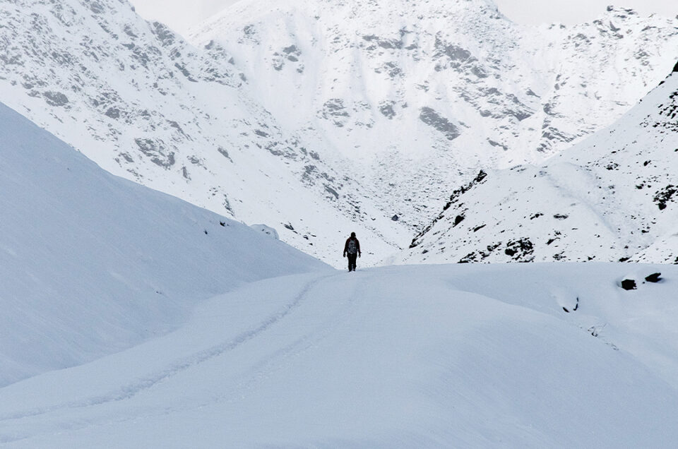 A lone hiker against the sprawling Alaskan mountain range in Hatcher Pass, captured by Matthew Hann.